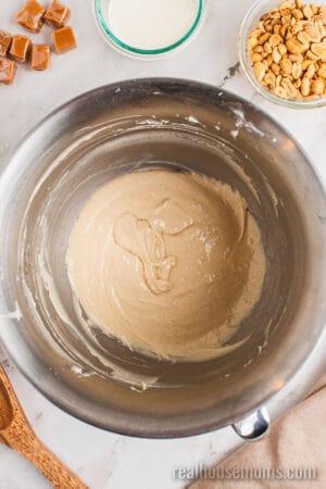looking down at snickers cheesecake filling in a stand mixer bowl