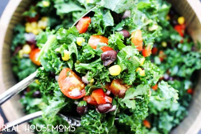 SOUTHWESTERN KALE SALAD is made with a variety fresh vegetables and kale tossed in a cumin vinaigrette for a summer side you can't beat!