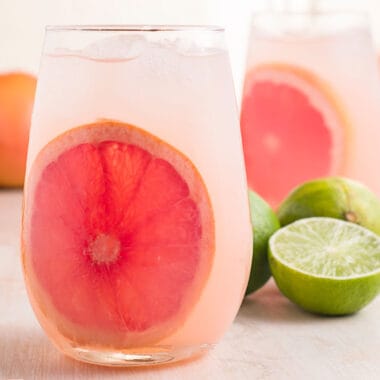 square image of sparkling paloma punch in a stemless wineglass with a grapefruit slice