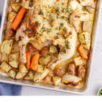 looking down at roasted spatchcock chicken and veggies on a baking sheet with recipe name at the bottom