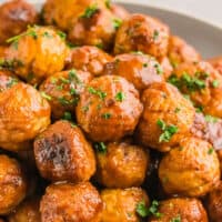 square image of instant pot meatballs piled up in a bowl with chopped parsley on top