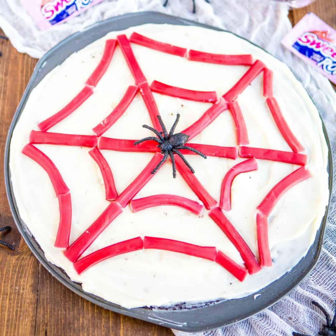 Spider Web Brownie Pizza is an easy dessert that'll be the talk of your Halloween party!! It's loaded with cream cheese frosting, SweeTARTS Ropes & spiders!