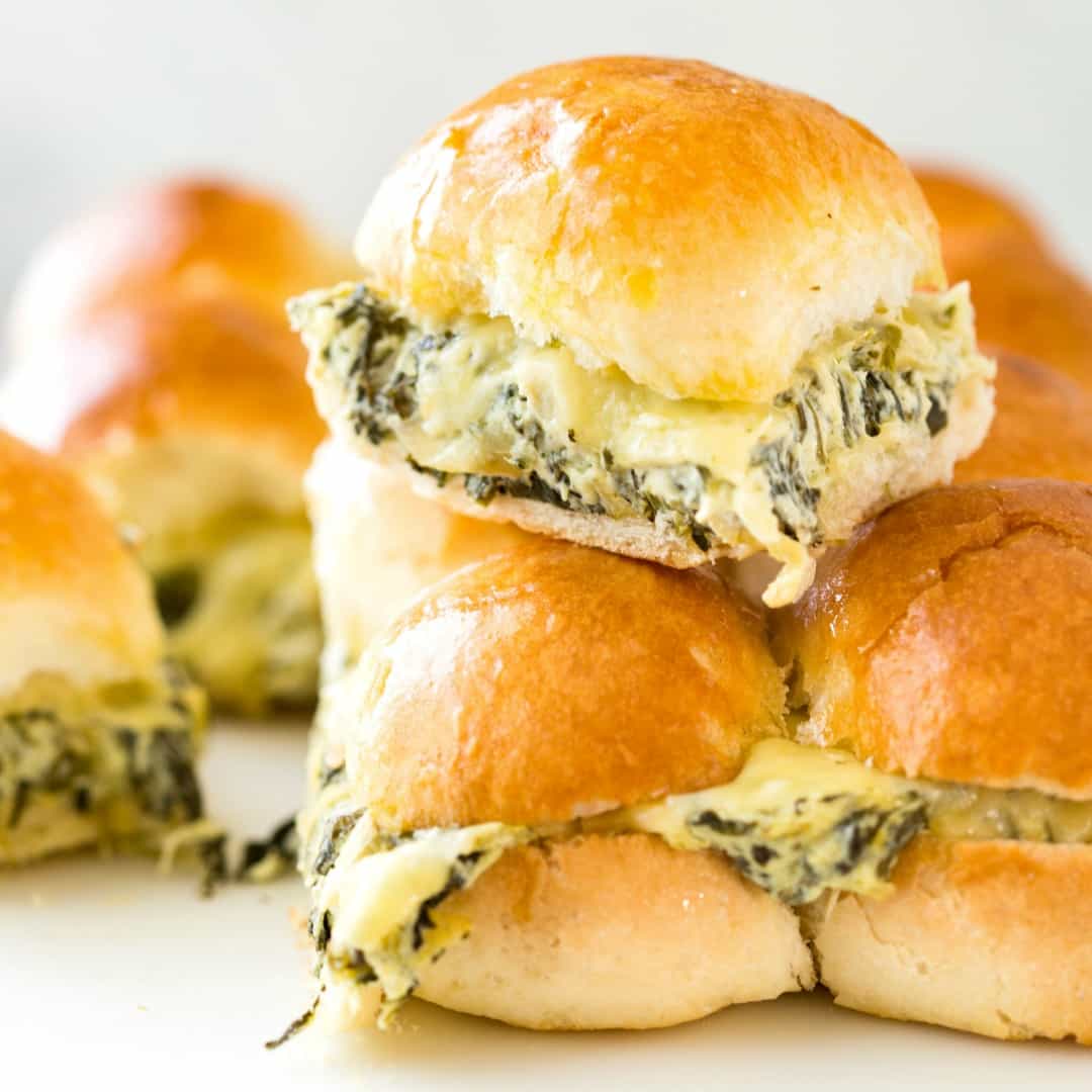 A total crowd pleaser! These Spinach Artichoke Dip Sliders are a great way to feed a crowd because you can make loads in one go. Warm and buttery, stuffed with Spinach Artichoke Dip and extra cheese.... I bet you can't stop at one!