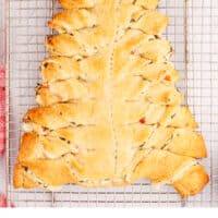 spinach dip stuffed crescent roll christmas tree on a wire rack with recipe name at the bottom