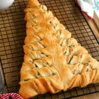 square img of spinach dip stuffed crescent roll Christmas tree on a wire rack