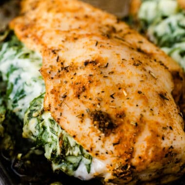 square image of spinach stuffed chicken on a baking sheet