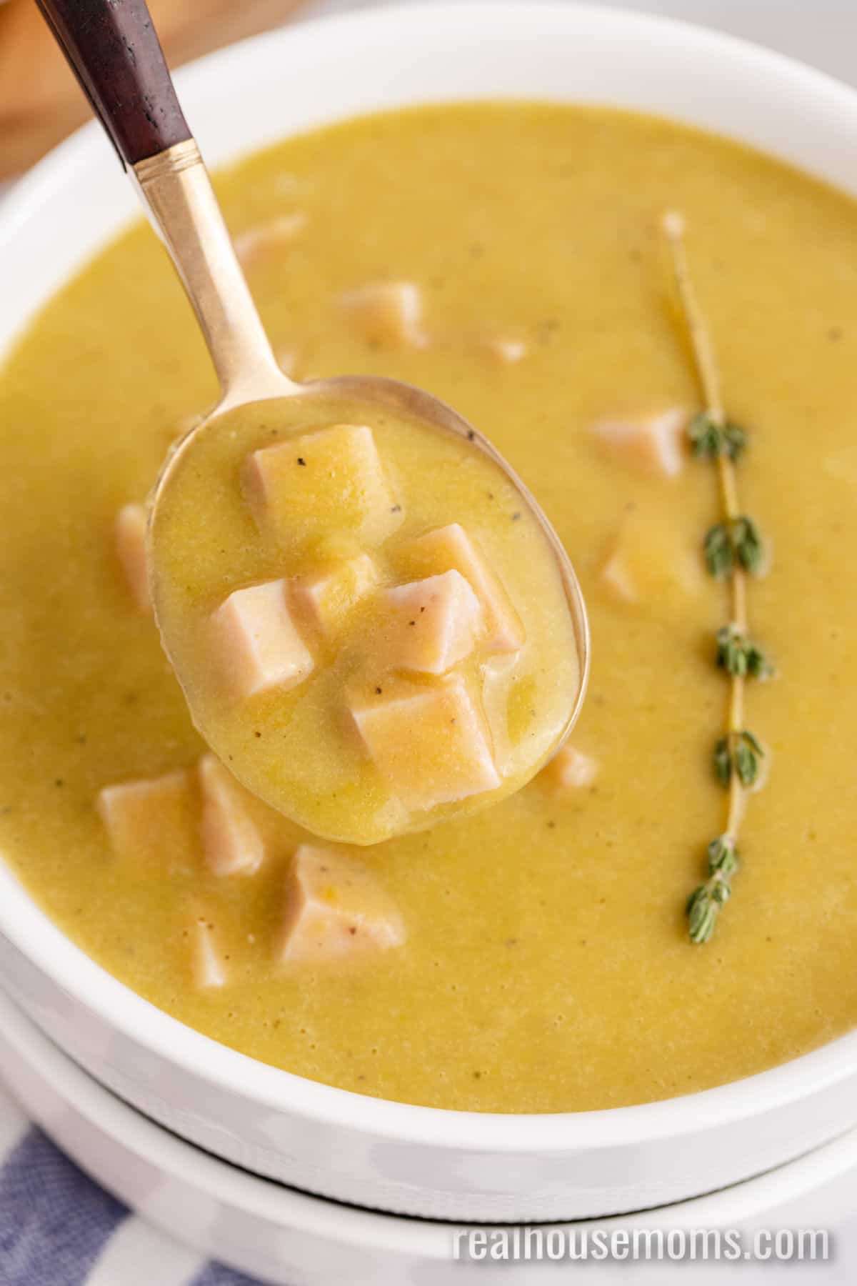 close up of a spoon of split pea soup over the bowl