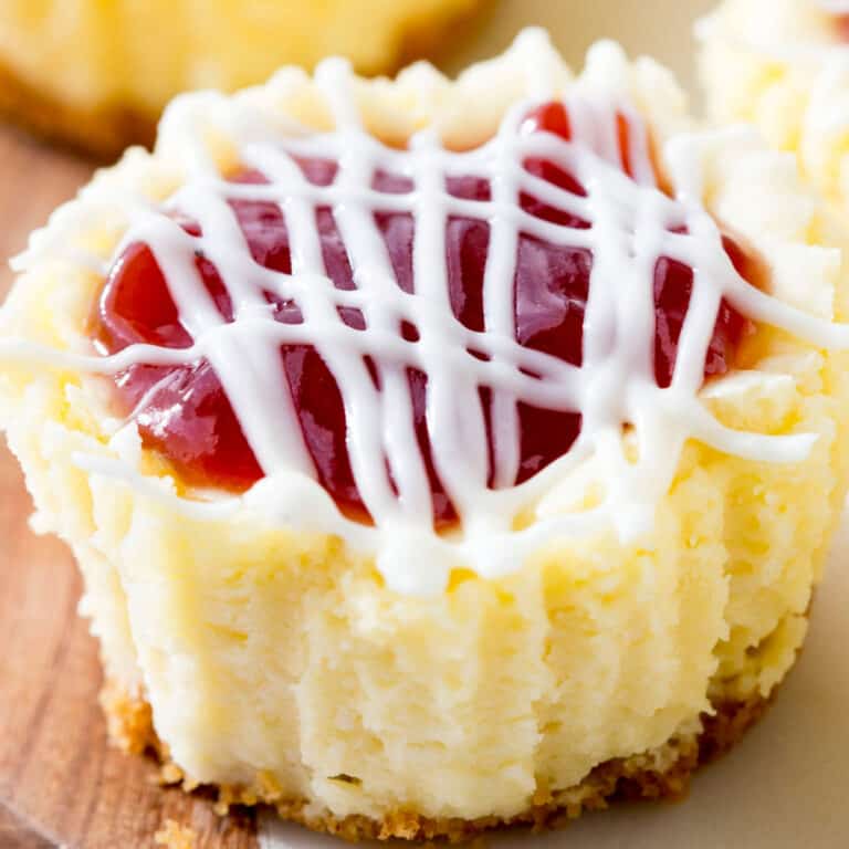 square image of mini strawberry cheesecake out of cupcake liner on a cutting board