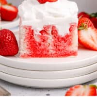 slice of strawberry poke cake on a plate with recipe name at the bottom