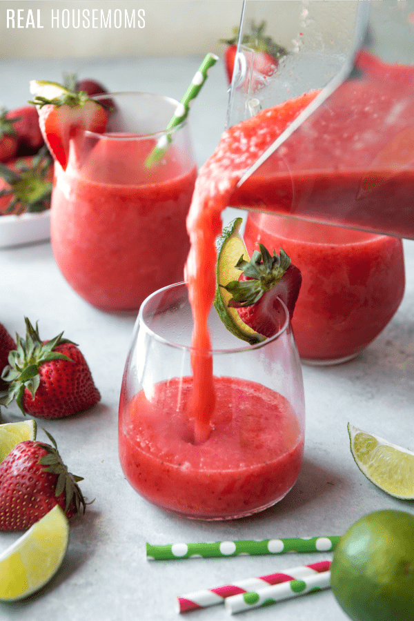 Strawberry & Lime Moscato Wine Slushie being poured into glasses from the blender