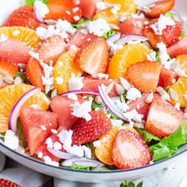 square close up image of strawberry & mandarin orange salad in a serving bowl