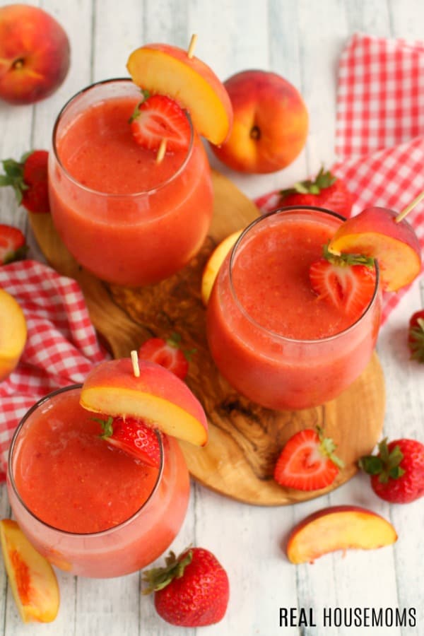 looking down at glasses of Strawberry Peach Frosé surrounded by fruit