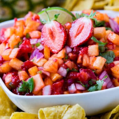 square close up image of strawberry pineapple salsa in a white bowl