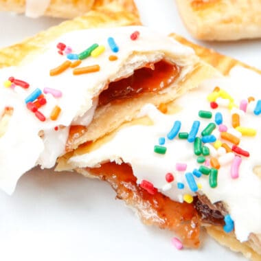 square image of a homemade strawberry pop tart broken in half to show filling