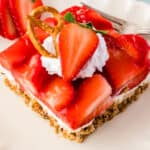 square close up image of a slice of strawberry pretzel salad on a plate
