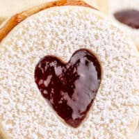 image of a strawberry sandwich cookie leaning against a stack of sandwich cookies with the title of the post on top of the image in red and black lettering