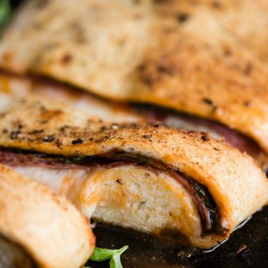 Italian Stromboli is a delicious hot sandwich loaded with pizza sauce, spinach, cured Italian meats, and melted mozzarella. Homemade pizza dough wraps around all the fillings to create a mouthwatering sandwich!