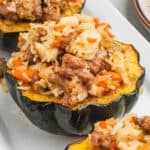 square image of stuffed acorn squash on a serving platter