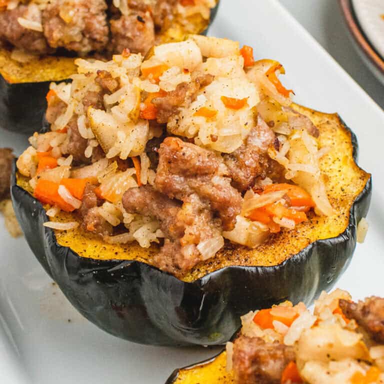 square image of stuffed acorn squash on a serving platter