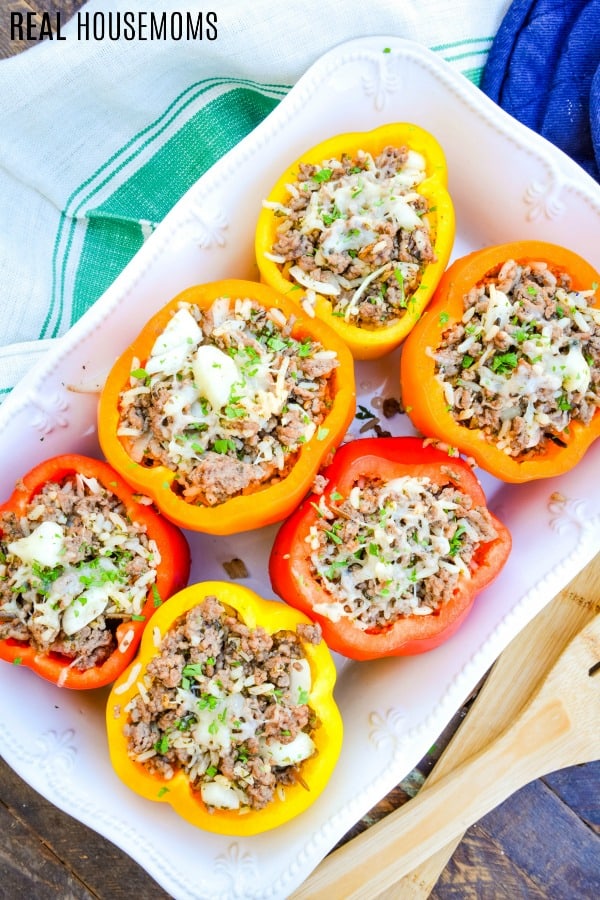 stuffed bell peppers in a baking dish topped with melted cheese