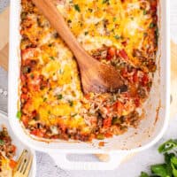 wooden spoon in a dish of stuffed pepper casserole with recipe name at the bottom