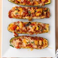 sausage stuffed zucchini boats on a platter with recipe name at the bottom