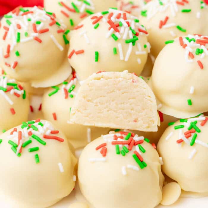 square image of sugar cookie truffles on a plate with one cut in half