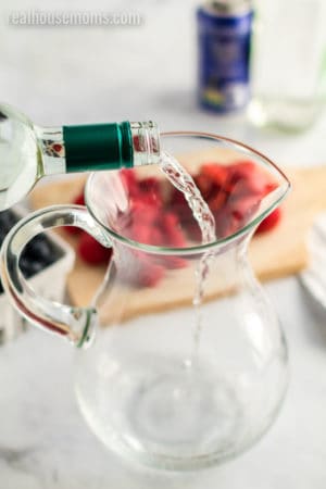 white wine being poured into a pitcher