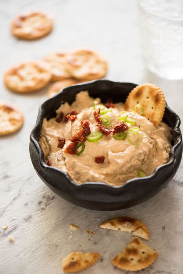 Sun Dried Tomato Dip in a serving bowl with crackers for dipping