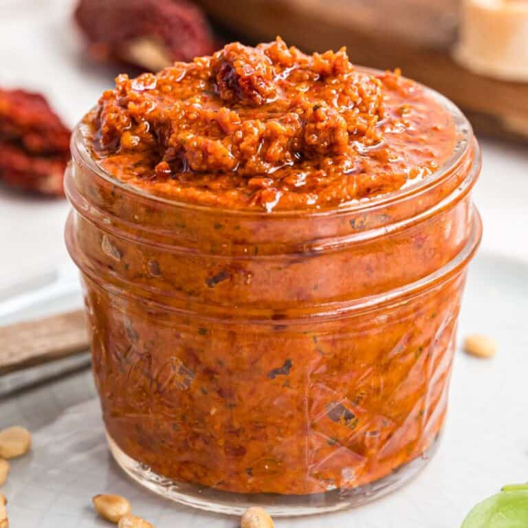 square image of sun dried tomato pesto in a small jar