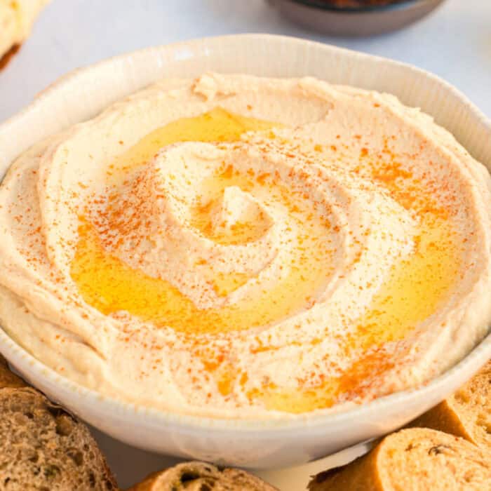 square close up image of a bowl of super creamy hummus