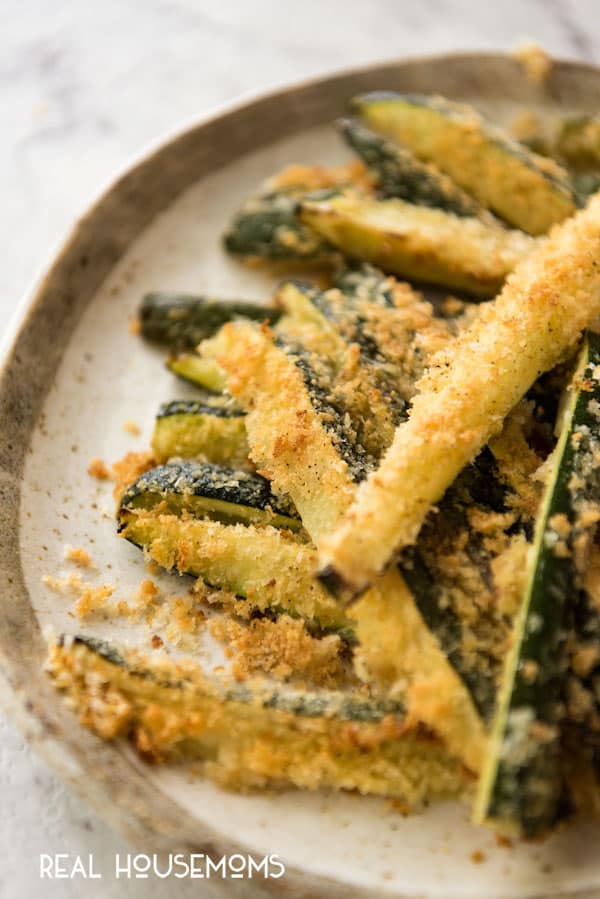 Close up of Super Easy Parmesan Crust Zucchini piled up on a plate.