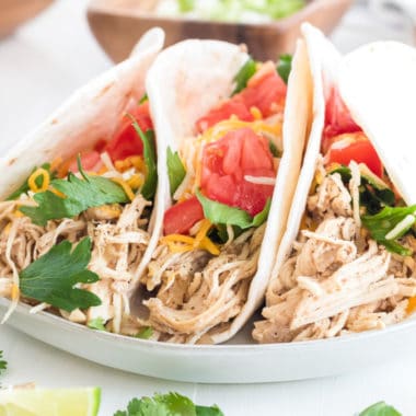 Super Easy Slow Cooker Chicken Tacos are the perfect weeknight meal! Let your crockpot do the hard work, then assemble your tacos and dig in!
