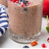 super food smoothie in a glass with a striped straw with recipe name at the bottom