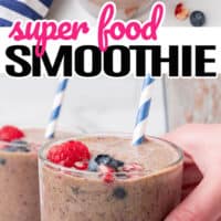 top picture of a super food smoothie with a paper straw topped with fruit, bottom picture is a hand holding a water glass full with super food smoothie. In the middle of the two pictures is the title of the post with pink and black lettering
