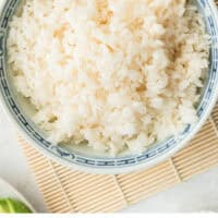 sushi rice in a bowl with a rice paddle with recipe name at the bottom