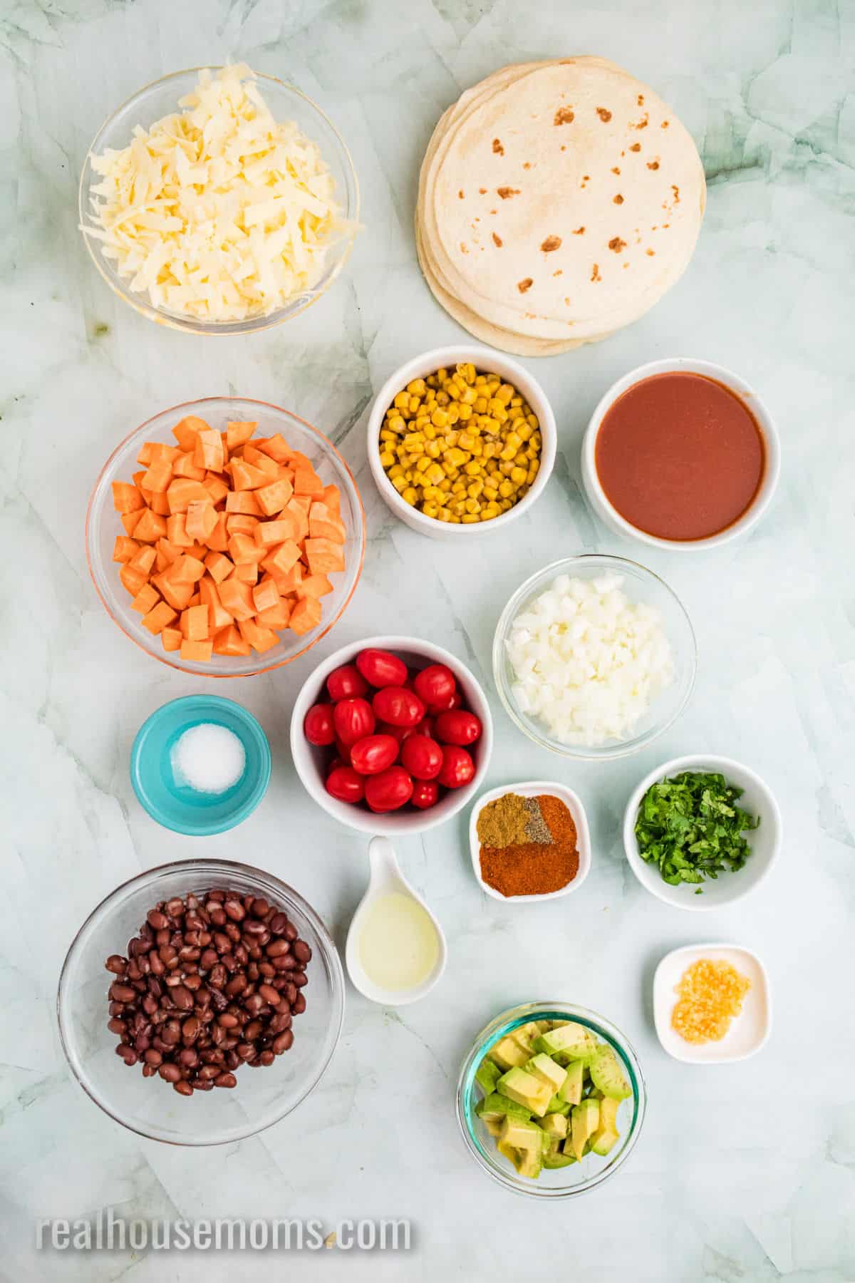 ingredients to make sweet potato black bean enchiladas in bowls on a counter