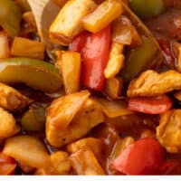 wooden spoon in a skillet of sweet and sour chicken with recipe name at the bottom