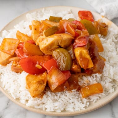 square image of sweet and sour chicken served over cooked white rice