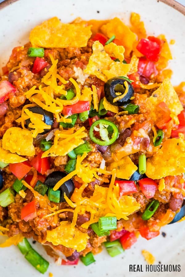 close up of taco casserole on a plate with tortilla chips