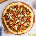 square image of a taco pizza on a wooden platter