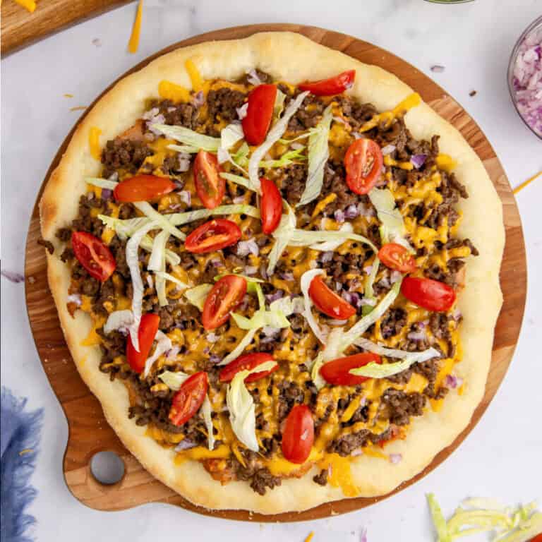 square image of a taco pizza on a wooden platter