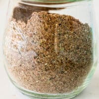 spoonful of taco seasoning over a jar with recipe name at bottom