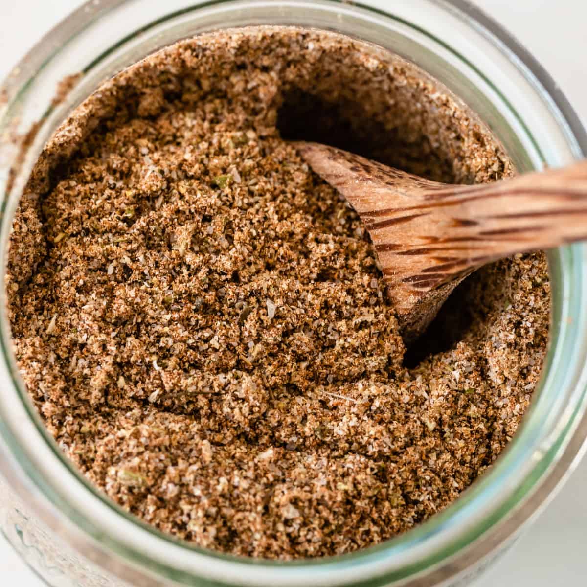 square image looking down into a jar or taco seasoning with a spoon