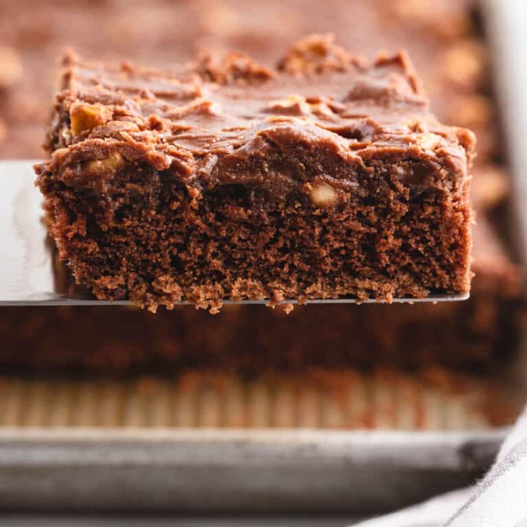 square image of a slice of texas sheet cake on a spatula