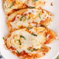 tilapia parmesan served on a platter with recipe name at the bottom
