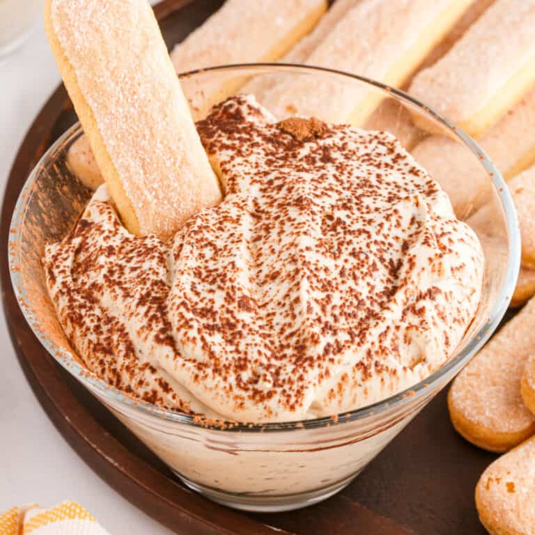 square image of ladyfinger cookie stuck into a bowl of tiramisu dip