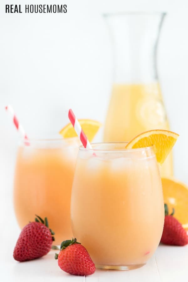 Tropical orange punch in glasses with straw and an orange slice
