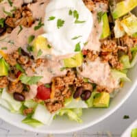 turkey taco salad in a bowl with a fork with recipe name at the bottom