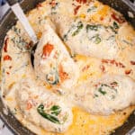 square image of tuscan chicken in a skillet with one chicken breast on a spoon